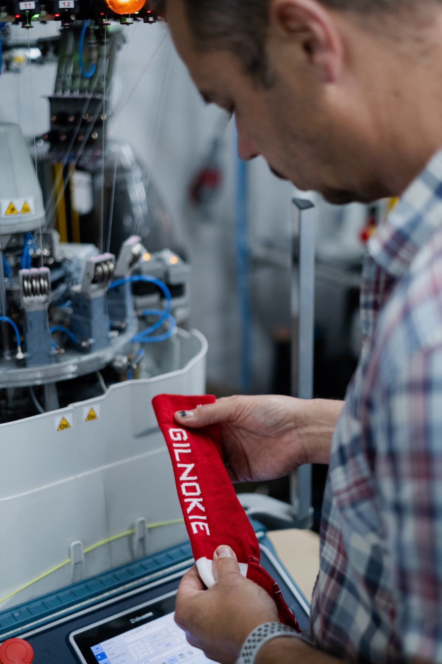 A photograph of a Gilnokie Sock and a sock knitting machine in the background.