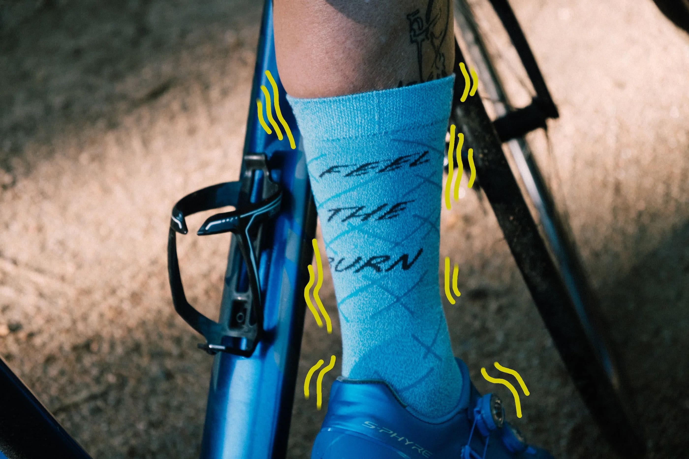 Close up photograph of a blue crew height cycling sock that has the words "feel the burn".